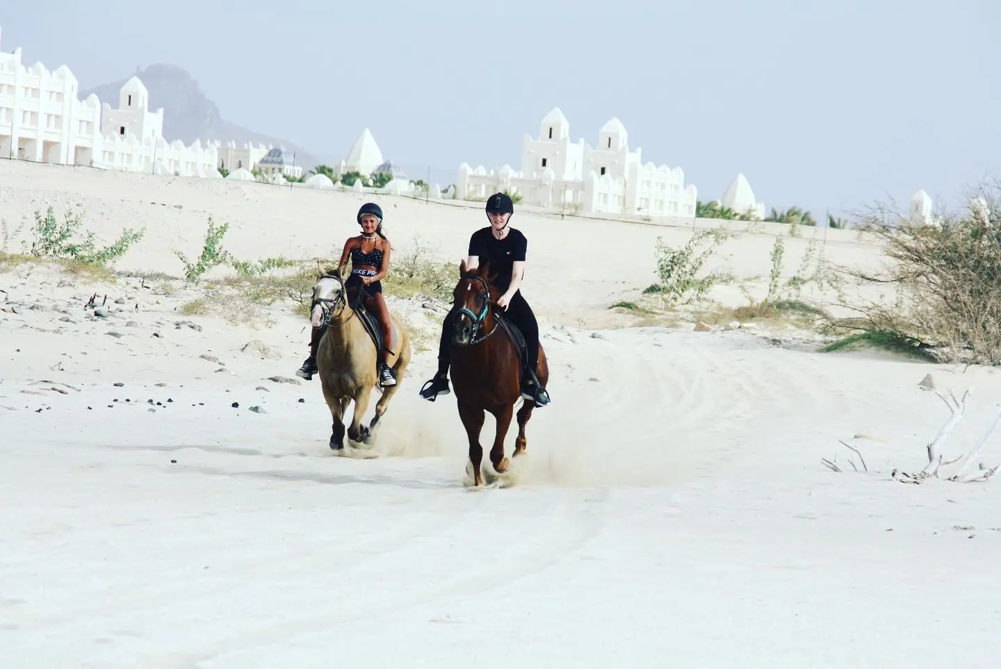 Two riders crossing the dunes near Riu Palace